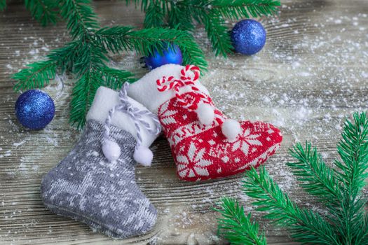 Christmas and New Year winter holiday snowbound composition of stockings on wooden space background with green fir tree branches and balls ornament
