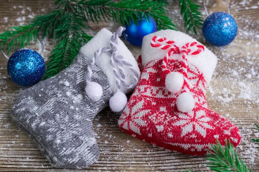 Christmas and New Year winter holiday snowbound composition of stockings on wooden space background with green fir tree branches and balls ornament