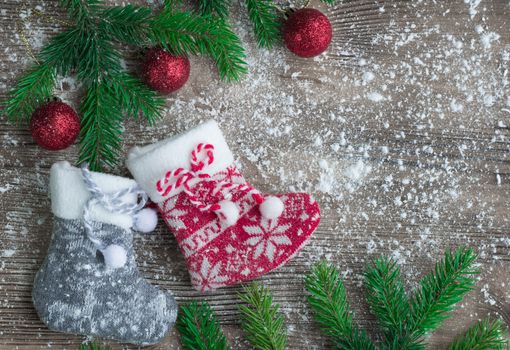 Christmas and New Year winter holiday snowbound composition of stockings on wooden space background with green fir tree branches and balls ornament