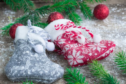 Christmas and New Year winter holiday snowbound composition of stockings on wooden space background with green fir tree branches and balls ornament