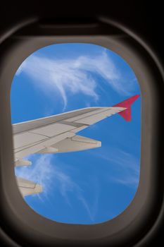 View from an airplane window on the wings and a beautiful blue sky with clouds.