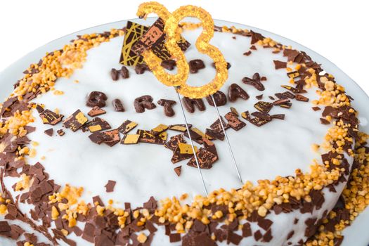 Birthday cake with candles and label in Happy Birthday against white background.
