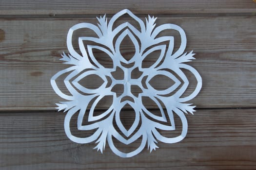 paper snowflake on the wooden table, high angle
