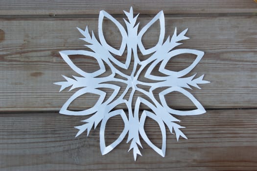 paper snowflake on the wooden table, high angle