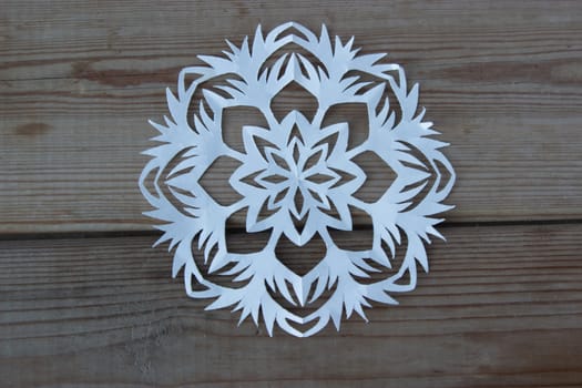 paper snowflake on the wooden table, high angle