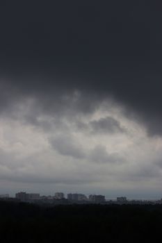 grey rainy foggy cityscape,  cloudy sky, distant buildings