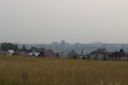 modern city buildings behind old farm houses