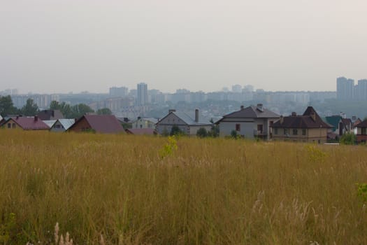 modern city buildings behind old farm houses