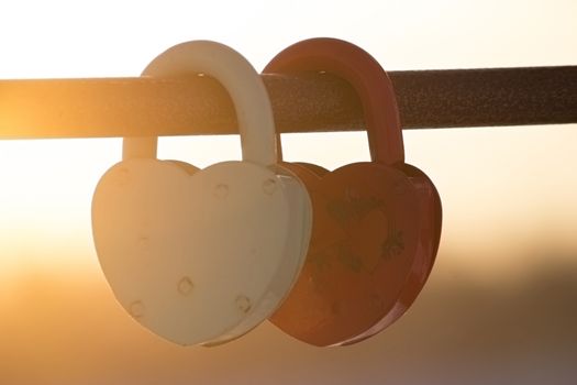 two heart shaped padlocks, beautiful sunset sunbeans