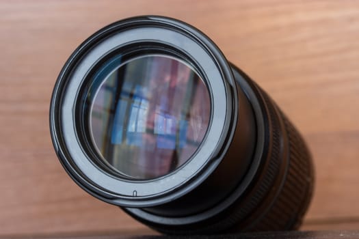 zoom lens of the reflex camera on the wooden background