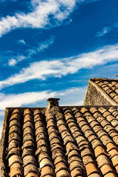 The ancient roof on a blue sky with clouds streaked