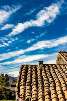 The ancient roof on a blue sky with clouds streaked