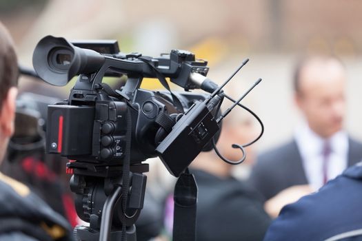 News conference. Covering an event with a television camera.