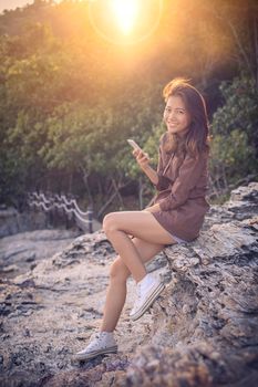 younger asian woman toothy smiling face happiness emotion with smart phone connecting in hand for digital modern lifestyle