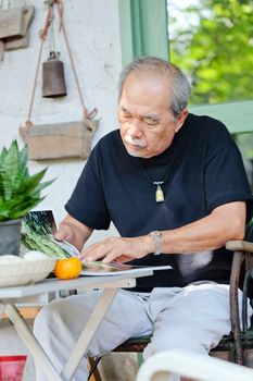 Senior man relaxing at home reading a book