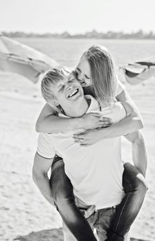 Young couple in love having fun and jumping on the beach. Black and white photography