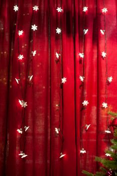 Christmas lights on a red background in studio.