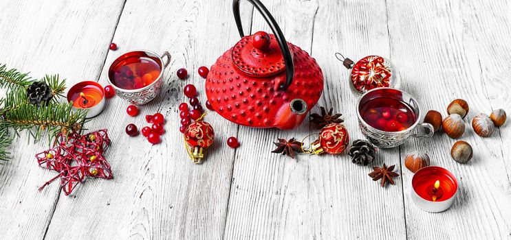 Cranberry tea in stylish iron cups at the Christmas background