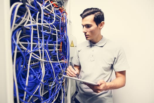 System administrator with digital tablet in a server room