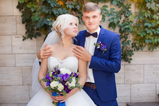 The groom gently put his arm around the shoulders of the bride for a walk in the countryside