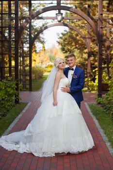 The groom gently put his arm around the shoulders of the bride for a walk in the countryside