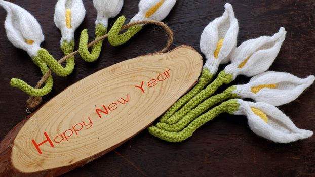 Amazing happy new year background from wood banner with nine of handmade white arum lily knit from yarn, diy home decor to make new year ornament in spring