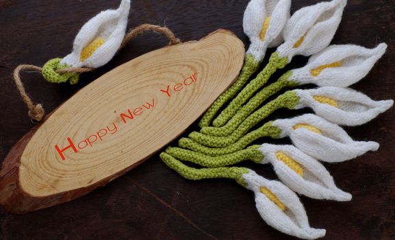 Amazing happy new year background from wood banner with nine of handmade white arum lily knit from yarn, diy home decor to make new year ornament in spring