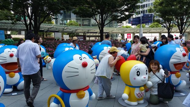 Tokyo, Japan - July 18, 2016: People and their family are enjoy visiting the Doraemon model exhibition held at Roppongi neighborhood, Tokyo. Two middle-aged women are taking themselves a photography with the Doraemon model.