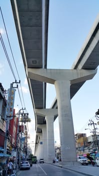 Bangkok, Thailand - November 12, 2016: The sky train track run through the urban downtown. People are moving in the public vehicle. Some people  are shopping for the street food.