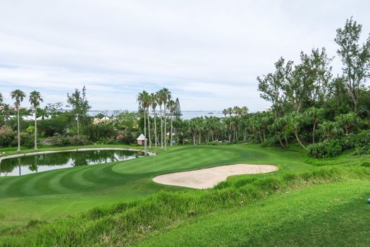 An lovely shot of a green and bunker overlooking the sea