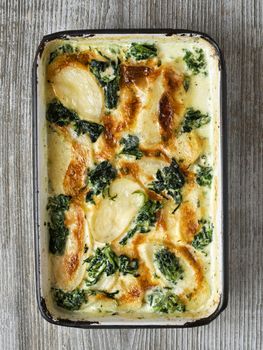 close up of rustic golden spinach potato gratin dauphinois