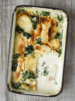 close up of rustic golden spinach potato gratin dauphinois