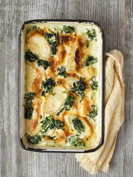 close up of rustic golden spinach potato gratin dauphinois