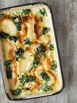 close up of rustic golden spinach potato gratin dauphinois
