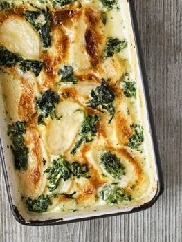 close up of rustic golden spinach potato gratin dauphinois