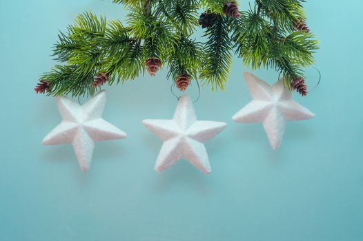 three toy star on spruce branch for Christmas card with place for text