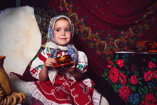 Adorable toddler girl  wearing a colorful national dress on tea party 