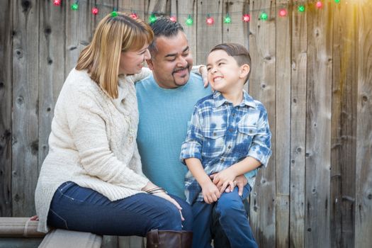 Happy Young Mixed Race Family Portrait Outside with Christmas Lights and Snow Effect.