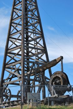 Vintage wooden oil rig displayed outdoors.