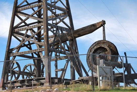 Vintage wooden oil rig displayed outdoors.