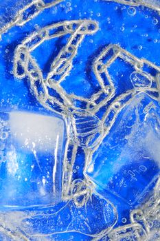 Metal chain under frozen water with ice against blue background