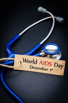 World AIDS day December 1st in paper tag with stethoscope on black background - health concept. Medical conceptual