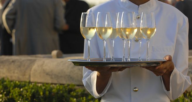 Professional male waiter in uniform serving champagne, Dri