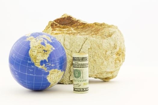 American currency with globe in front of firm rock reflects the global influences of economic policies. 
Horizontal still life with copy space. 