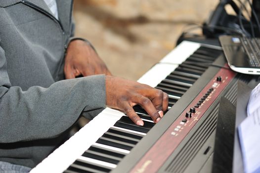 A close up image of male hands playing the piano expertly