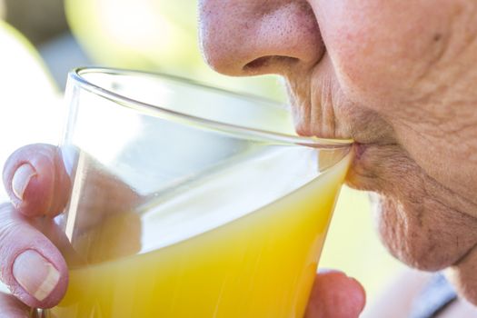 Close up Senior Woman drinking a glass of fresh juice storm