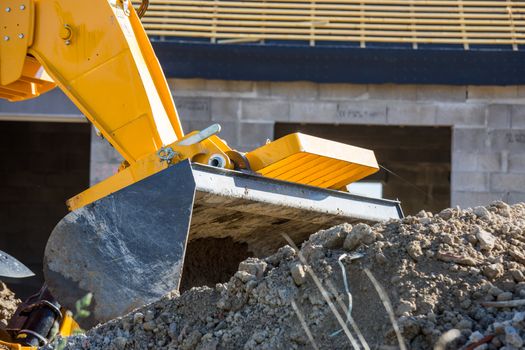 An excavator unloading white sand with water at a construction site