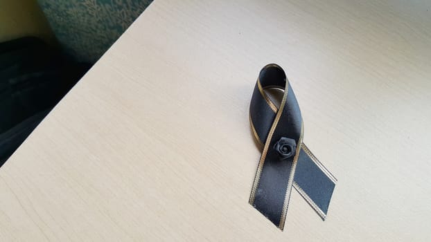 Black bow on the wooden desk.