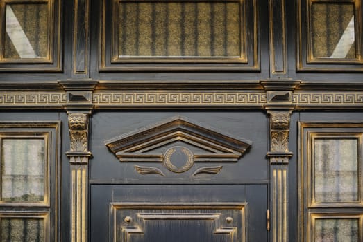 Wood carving with arch above the door in an old building.