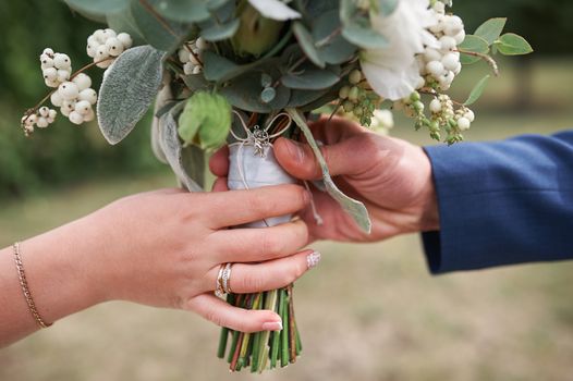 groom gives the bride a wedding bouquet close-up.